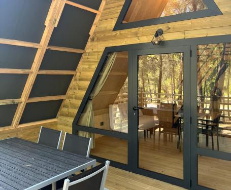 A-frame cabin with wooden deck and large windows.