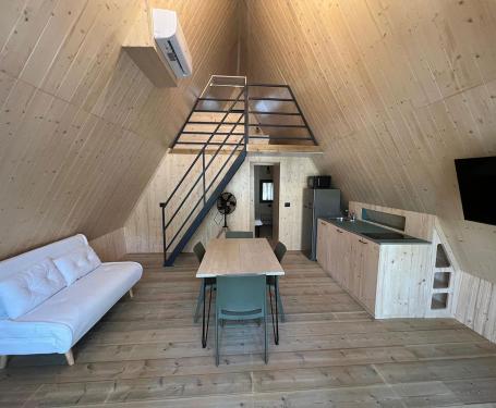 Accogliente casa di legno con soppalco, cucina e soggiorno.