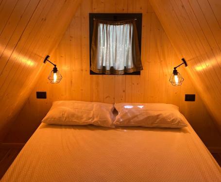 Accogliente camera da letto in legno con luci soffuse e piccola finestra.